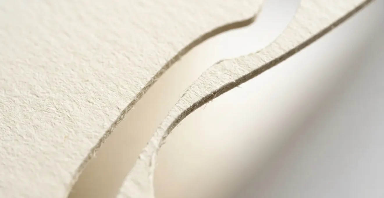 Vue macro d'une découpe précise sur papier épais révélant des détails complexes et des formes originales