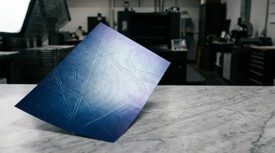 Effet de lumière sur papier nacré bleu nuit avec motifs géométriques en relief