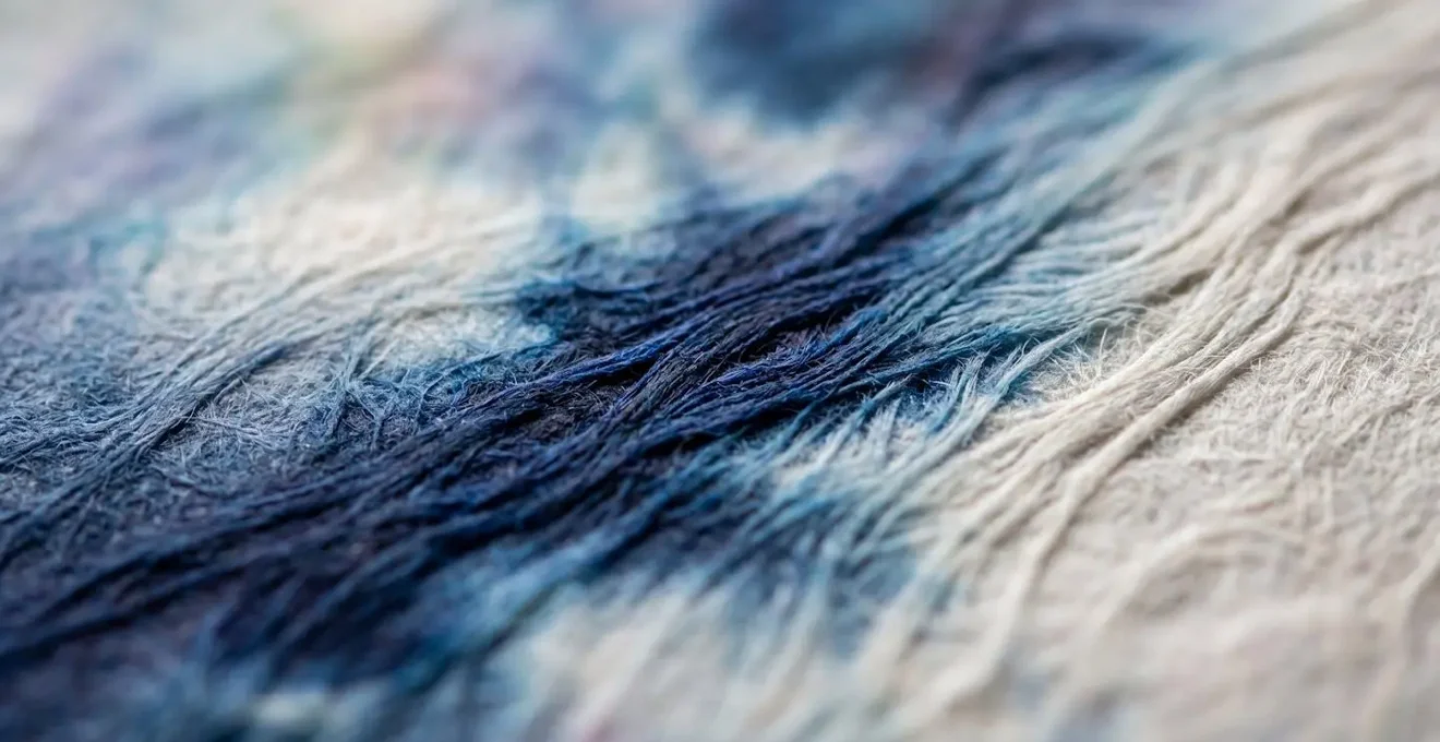 Vue macro d'un aplat de couleur sur papier texturé montrant la fusion subtile de l'encre avec les fibres
